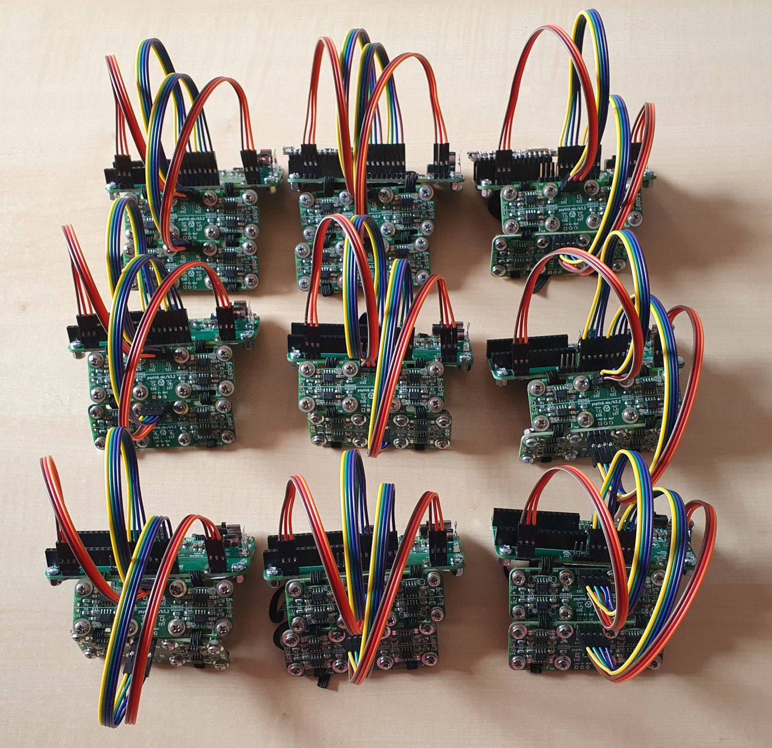 Photo of the same PCBs in an assembled form, showing 9 assembled PsyLinks